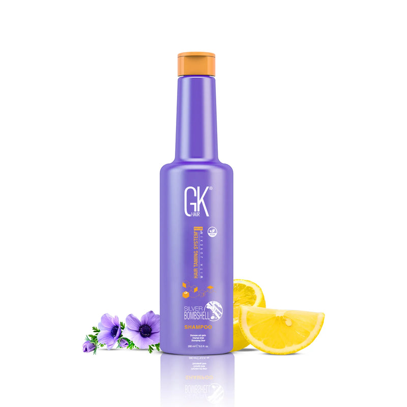 GK Hair Silver Bombshell Shampoo 280 ml purple bottle with an orange screw cap, purple anemones and lemon slices behind